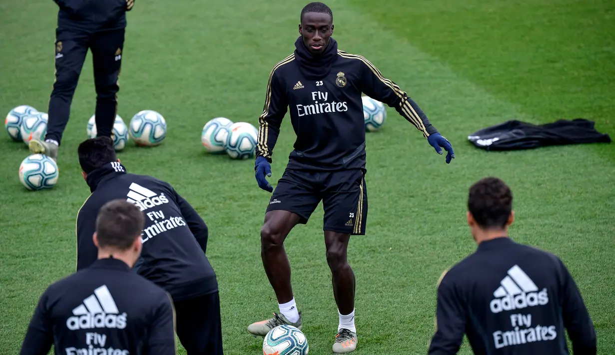 Bek Real Madrid, Ferland Mendy (tengah) mengumpan bola saat mengikuti sesi latihan tim di fasilitas olahraga Real Madrid City di Madrid (17/12/2019). Real Madrid akan bertanding melawan Barcelona dalam laga El Clasico di Nou Camp. (AFP/Javier Soriano)