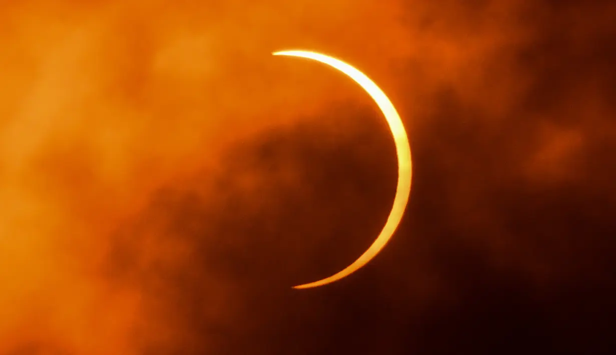 Bulan bergerak di depan Matahari saat berlangsungnya gerhana matahari cincin (Annular Solar Eclipse) yang terlihat dari langit New Delhi, india, Minggu (21/6/2020). Sebagian penduduk Bumi bisa menyaksikan fenomena langka, Gerhana Matahari Cincin. (Jewel Samad / AFP)