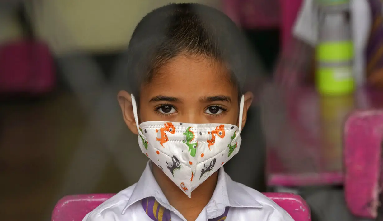 Seorang siswa sekolah dasar yang mengenakan masker duduk di ruang kelas sebuah sekolah di Kolombo, Sri Lanka, 25 Oktober 2021. Sri Lanka memulai kembali semua sekolah dasar yang telah ditutup lebih dari enam bulan karena pandemi COVID-19. (AP Photo/Eranga Jayawardena)