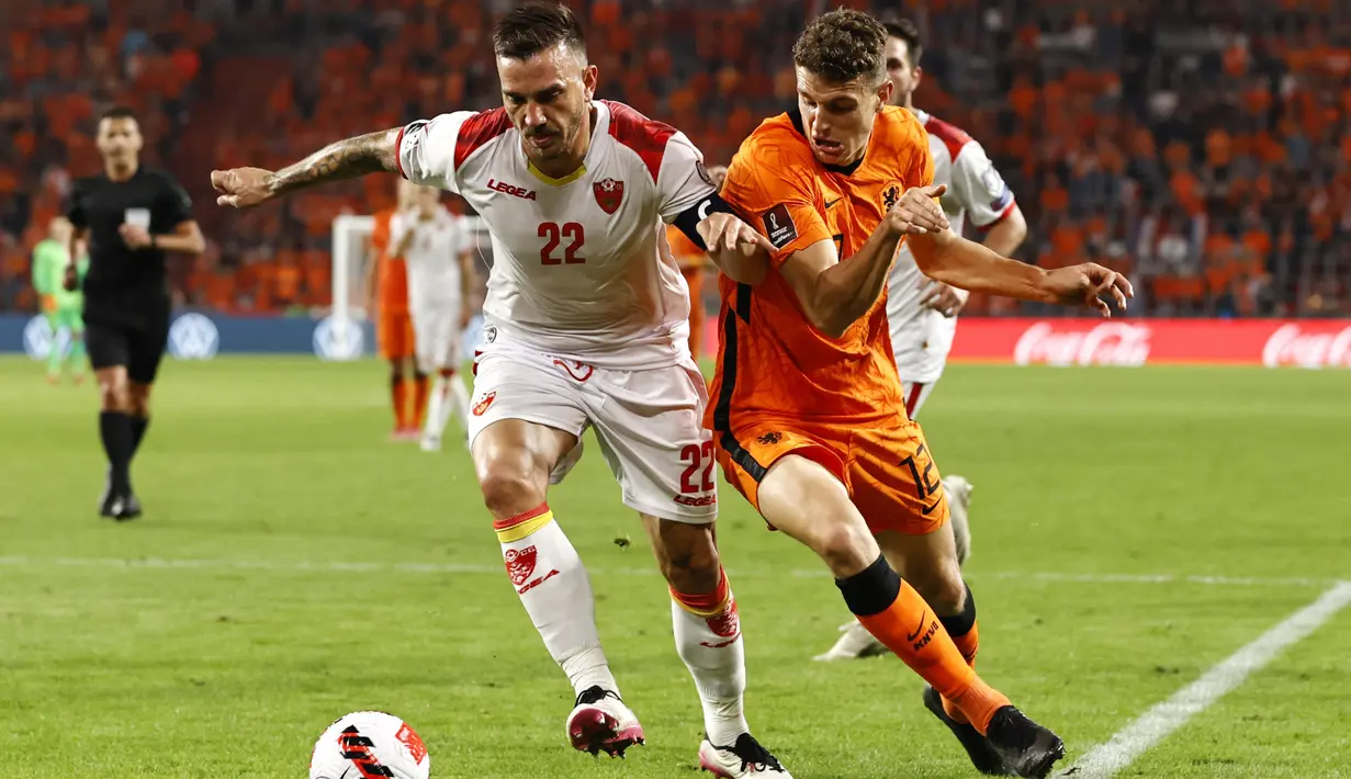 Penyerang Montenegro, Marko Simic bersaing dengan gelandang timnas Belanda Guus Til pada laga lanjutan kualifikasi Piala Dunia 2022 di Stadion Phillips, Minggu (5/8/2021) dini hari WIB. Belanda menggilas Montenegro empat gol tanpa balas. (MAURICE VAN STEEN/ANP/AFP)