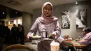 Pegulat hijab Malaysia, Nor "Phoenix" Diana membawa makan malamnya di sebuah restoran di Kuala Lumpur pada 15 Juli 2019. Kecintaan Nor Diana pada olahraga gulat baru dimulai saat usianya masih 14 tahun berawal ketika ia sering bermain gim bersama adik laki-lakinya. (Mohd RASFAN/AFP)