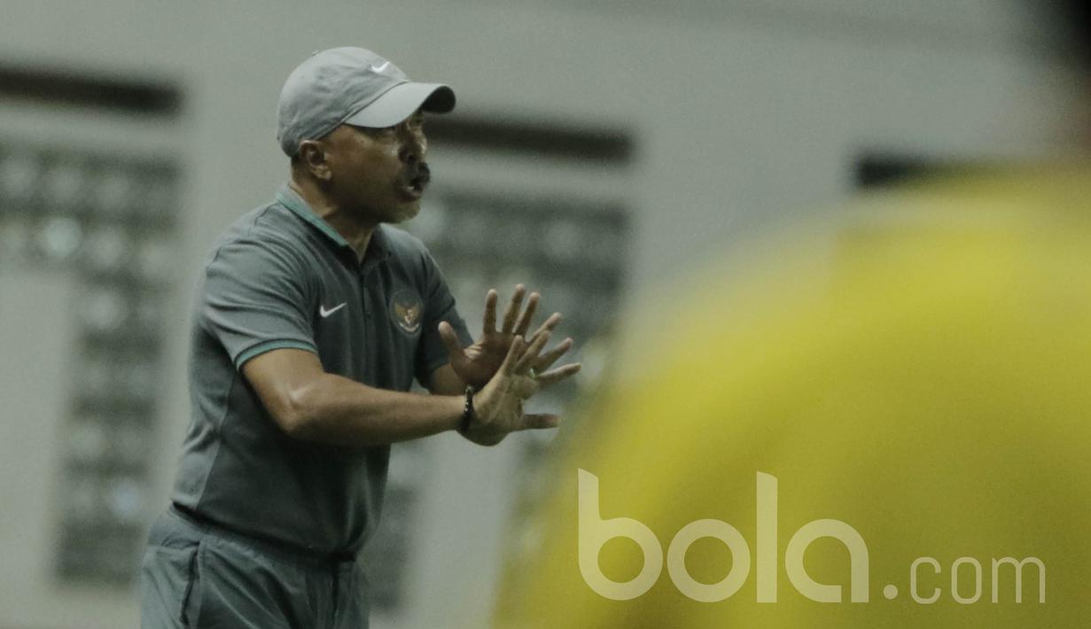 Pelatih Timnas Indonesia U-16, Fachri Husaini, memberikan arahan kepada anak asuhnya saat melawan Singapura di Stadion Wibawa Mukti, Cikarang, Kamis, (8/6/2017). Indonesia menang 4-0. (Bola.com/M Iqbal Ichsan)