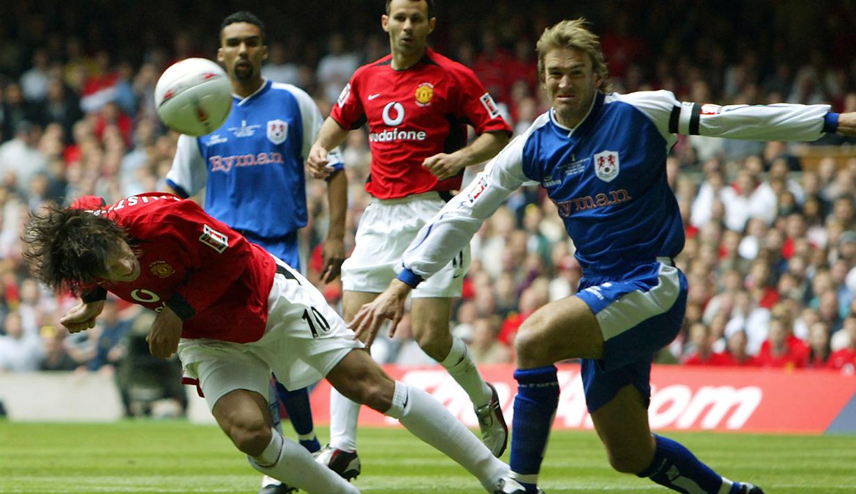 Striker Manchester United, Ruud van Nistelrooy (kiri) melepaskan sundulan ke gawang Millwall pada laga final Piala FA 2003/2004 di Millennium Dome, Cardiff, Wales (22/5/2004). Manchester United menjuarai Piala FA 2003/2004 setelah mengalahkan Millwall 3-0 lewat gol-gol dari Cristiano Ronaldo dan brace Ruud van Nistelrooy. (AFP/Adrian Dennis)