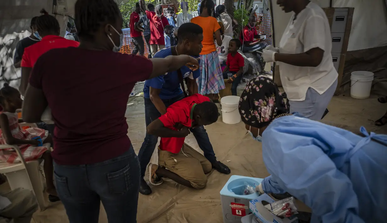 Seorang pemuda yang menderita gejala kolera ditolong setibanya di sebuah klinik yang dikelola oleh Doctors Without Borders di Port-au-Prince, Haiti, Kamis, 27 Oktober 2022. Untuk pertama kalinya dalam tiga tahun, orang-orang di Haiti telah sekarat karena kolera, meningkatkan kekhawatiran tentang skenario yang berpotensi menyebar cepat dan menghidupkan kembali ingatan tentang epidemi yang menewaskan hampir 10.000 orang satu dekade lalu. (AP/Ramon Espinosa)