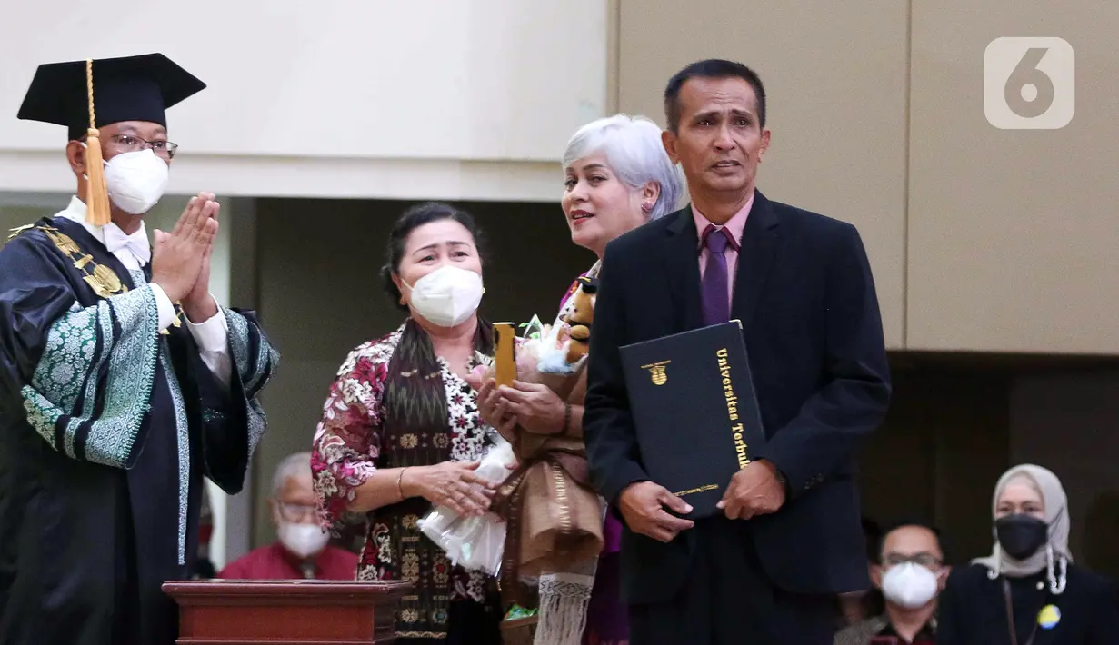 Ayah Brigadir Nofriansyah Yosua Hutabarat atau Brigadir J, Samuel Hutabarat (kanan) menerima ijazah dari Rektor Universitas Terbuka Ojat Darojat saat mewakili anaknya mengikuti prosesi wisuda di Universitas Terbuka, Pamulang, Tangerang Selatan, Banten, Selasa (23/8/2022). Kehadiran ayah Brigadir J saat prosesi wisuda didampingi saudaranya Ramos Hutabarat dan kerabat satu marga, Irma Hutabarat. (Liputan6.com/Herman Zakharia)