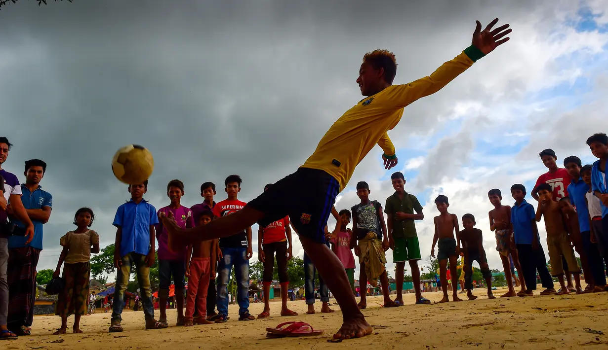Seorang penggemar Neymar, Mohammad Jahangir Alam menunjukkan keterampilan sepak bolanya di kamp pengungsi Kutupalong di Ukhia, Bangladesh, 19 Juli 2018. Jahangir Alam mencukur rambut dan mewarnainya dengan gaya pemain bola Brasil itu. (AFP/Munir UZ ZAMAN)