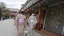 Pengunjung berpakaian kimono yang mengenakan masker untuk melindungi diri dari penyebaran virus corona berjalan-jalan di distrik Asakusa di Tokyo, Jepang, Rabu (14/10/2020). Tokyo mengonfirmasi lebih dari 170 kasus virus corona baru pada hari Rabu. (AP Photo/Koji Sasahara)