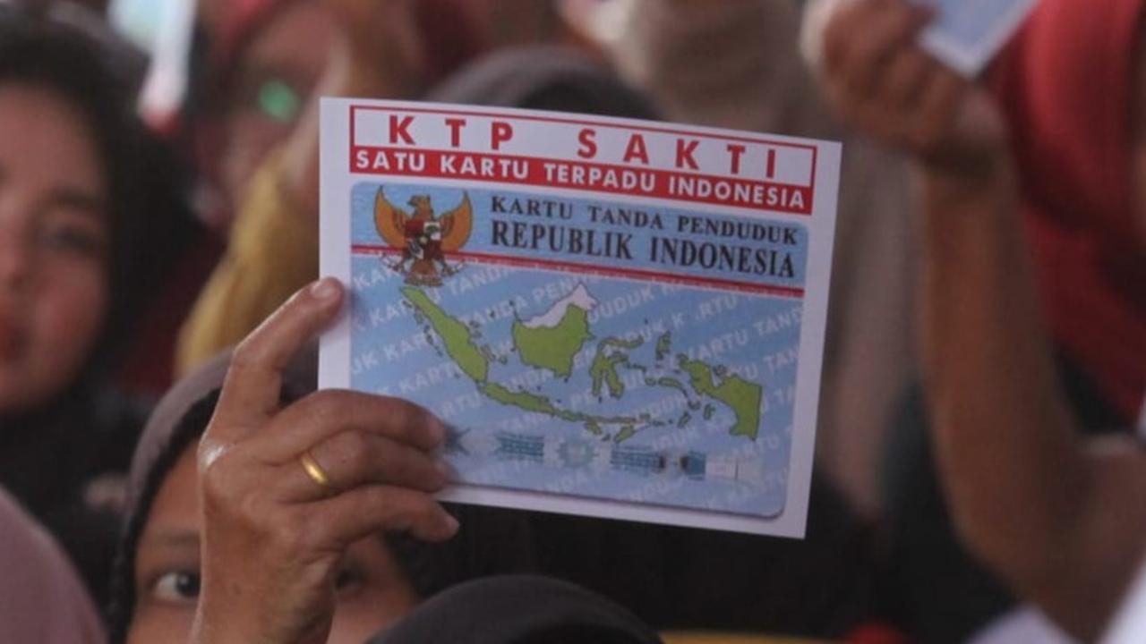 Warga memegang 'KTP Saksi' saat mengikuti sosialisasi pencoblosan.