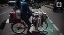 Pengguna jalan melintas di samping jalur sepeda yang di bongkar di kawasan Cikini, Jakarta, Selasa (19/11/2019). Jalur sepeda berumur 2 bulan tersebut dibongkar akibat proyek pelebaran trotoar. (Liputan6.com/Faizal Fanani)