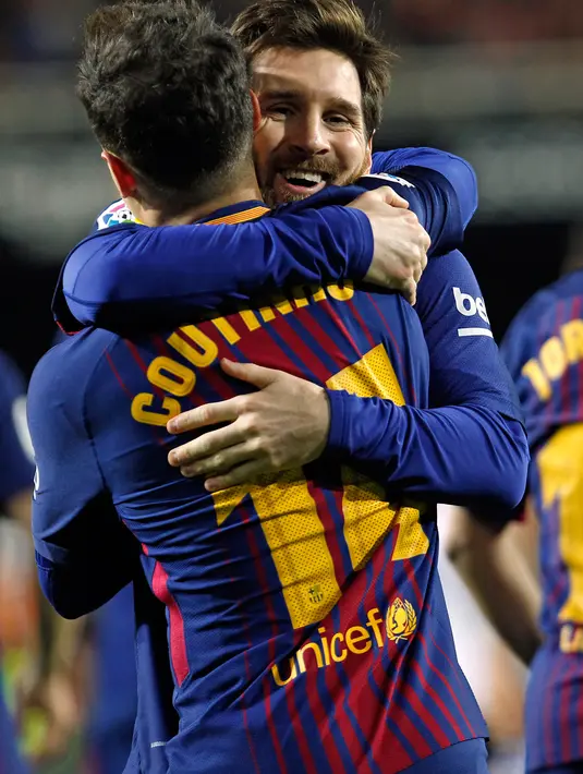 Philippe Coutinho dipeluk Lionel Messi usai mencetak gol ke gawang Valencia saat pertandingan Copa del Rey di stadion Mestalla di Valencia (8/2). Sejak babak pertama bergulir, Barca mampu menguasai jalannya pertandingan. (AP Photo/Alberto Saiz)