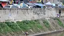Anak-anak bermain di Kali Ciliwung, Kampung Pulo, Jakarta, Minggu (27/1). Keterbatasan ekonomi menjadikan Kali Ciliwung sebagai tempat pilihan bagi anak-anak setempat untuk menghabiskan waktu bermain saat libur sekolah. (Merdeka.com/Iqbal Nugroho)