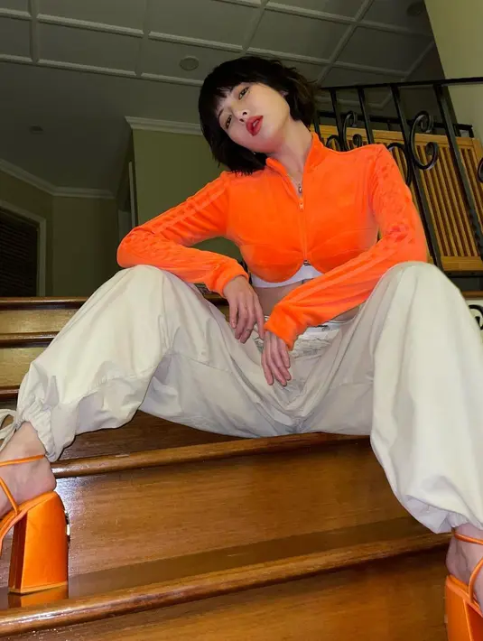 Dengan outfit yang lebih bright, HyunA tetap tidak ragu pamer perut ratanya. Ia memadukan crop top suede long sleeve dengan pants yang trendy berwarna beige. [instagram/hyunah_aa]