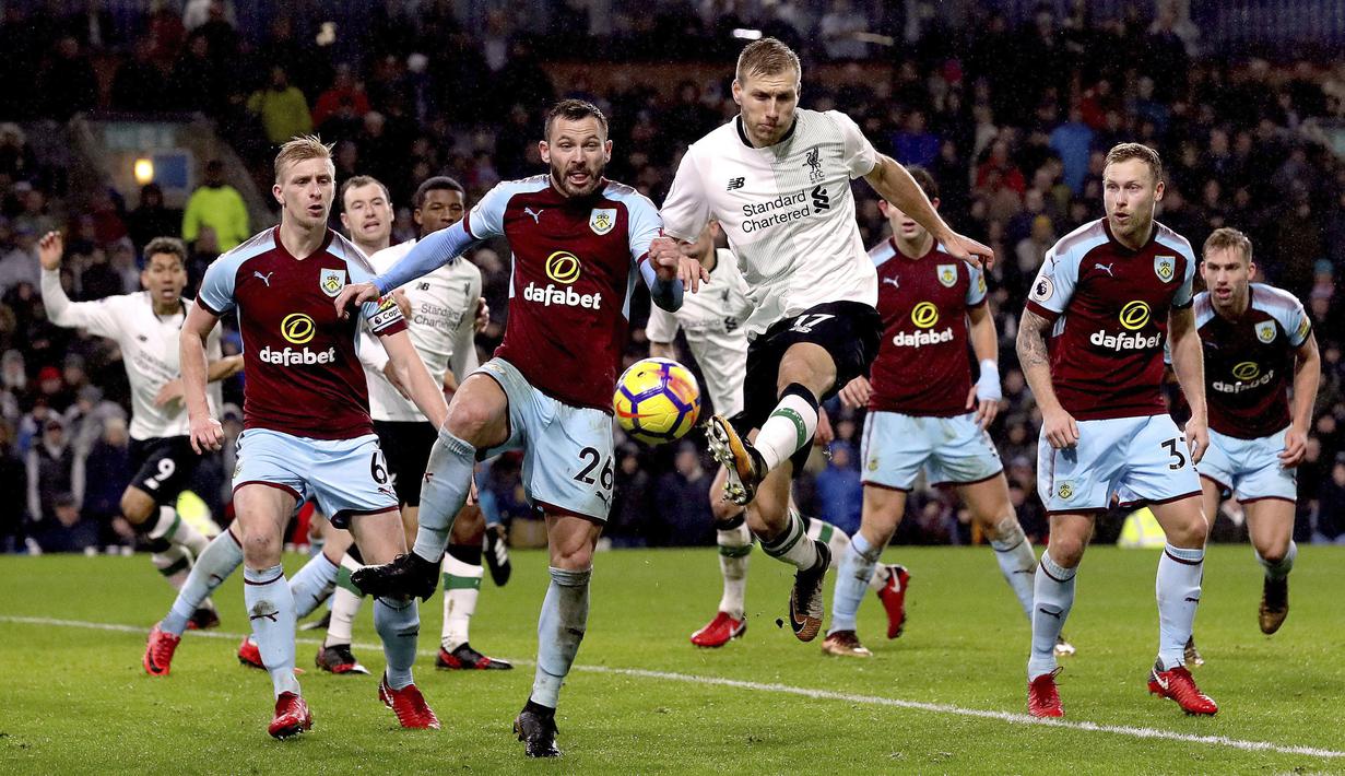 Aksi pemain Liverpool, Ragnar Klavan (tengah) melepaskan tembakan melewati adangan pemain Burnley, Phil Bardsley pada lanjutan Premier League di Turf Moor, Burnley, (1/1/2018). Liverpool menang 2-1 atas Burnley. (Martin Rickett/PA via AP)