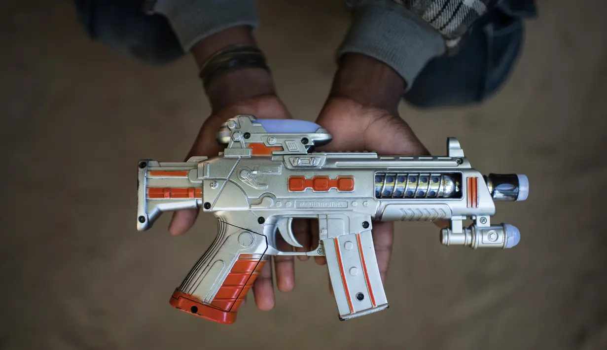 Bocah Rohingya berumur 9 tahun, Saiful Islam menunjukkan pistol mainan di kamp pengungsi Shamlapur di Cox's Bazar (1/12). (AFP Photo/Ed Jones)