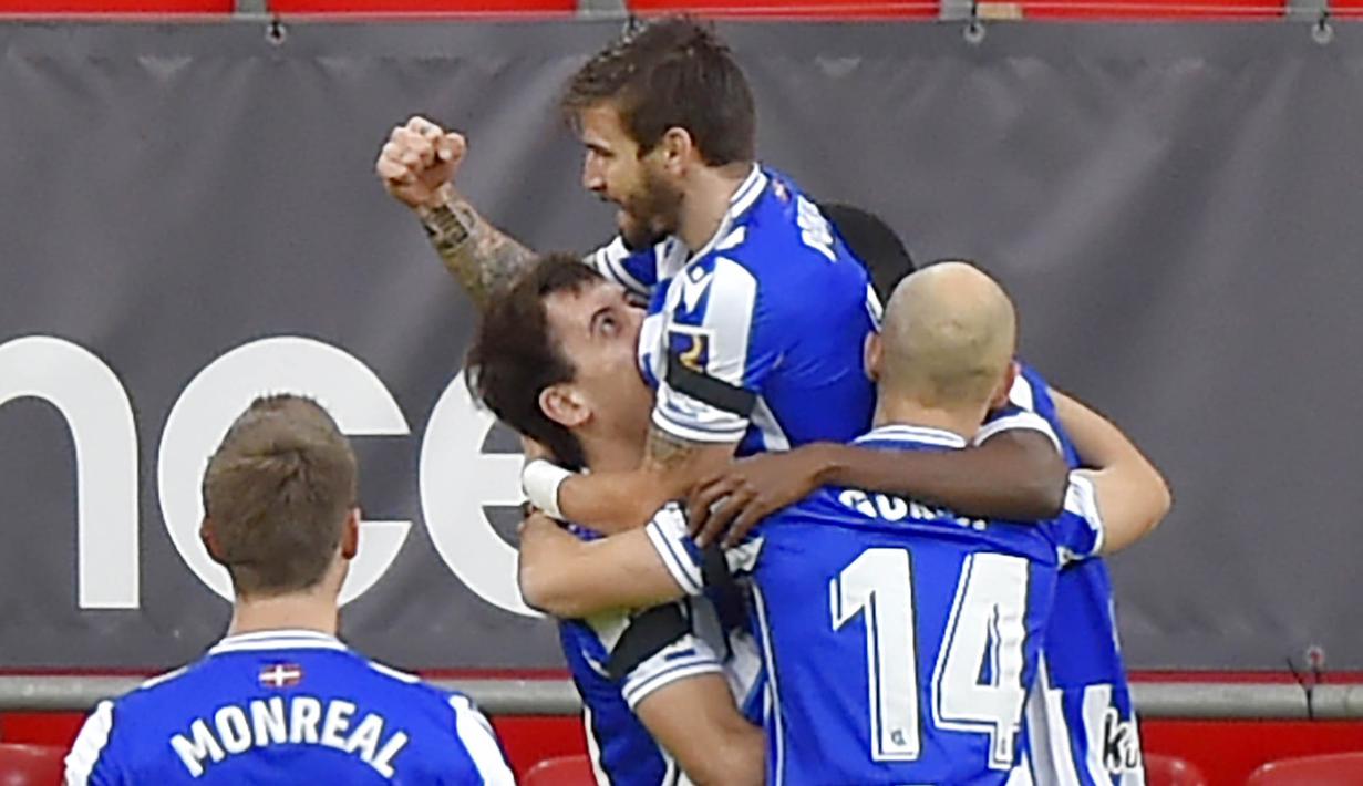 Para pemain Real Sociedad merayakan gol yang dicetak oleh Portu ke gawang Athletic Bilbao pada laga liga Spanyol di Stadion San Mames, Kamis (31/12/2020). Real Sociedad menang dengan skor 1-0. (AFP/Ander Gillenea)