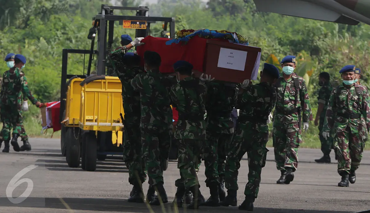 Petugas mengangkat peti jenazah dari pesawat Hercules bernomor ekor 1321 ke pesawat pengganti jenis CN 295, di Lanud Soewondo, Medan, Jumat (3/7). Pemindahan tersebut karena muncul percikan api di bagian kokpit Hercules C-130. (Liputan6.com/Johan Tallo)