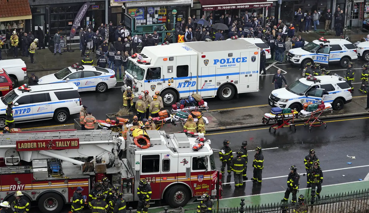 Personel darurat berkumpul di pintu masuk halte kereta bawah tanah di wilayah Brooklyn, New York, Amerika Serikat, 12 April 2022. Sejumlah orang terluka dalam penembakan yang terjadi pada jam sibuk. (AP Photo/John Minchillo)