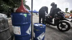 Petugas mengosongkan tangki bensin sepeda motor peserta mudik gratis sebelum dibawa ke atas truk di Terminal Pulo Gadung, Jakarta, Selasa (26/4/2022). Mudik gratis digelar untuk tujuan ke 17 kota dan kabupaten di Jawa dan Sumatera. (merdeka.com/Iqbal S. Nugroho)