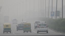 Kendaraan bermotor melintas di sepanjang jalan di tengah kondisi kabut asap yang menyelimuti New Delhi, India, Minggu (7/11/2021). Ibu kota New Delhi diselimuti udara beracun pada Sabtu kemarin karena tingkat polusi yang sangat tinggi pasca-perayaan festival besar agama Hindu. (Money SHARMA/AFP)