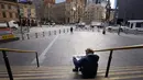 Seorang pria membaca koran di tangga Stasiun Flinders Street di Melbourne, Australia, Rabu (11/8/2021). Lima juta orang di kota terbesar kedua di Australia tersebut akan tetap berada di bawah perintah tinggal di rumah, setidaknya selama seminggu lagi. (AAP Image/Daniel Pockett)
