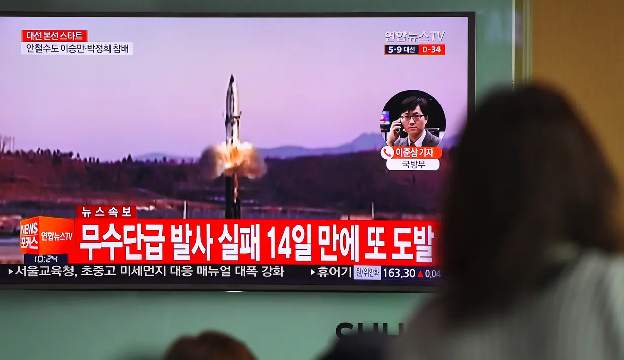 Layar televisi menyiarkan berita terkait Korea Utara yang menembakkan rudal ke arah Laut Jepang, di stasiun kereta Seoul, Selasa (5/4). Tembakan dilancarkan jelang pertemuan antara Presiden AS Donald Trump dan Presiden China Xi Jinping. (JUNG Yeon-Je/AFP)
