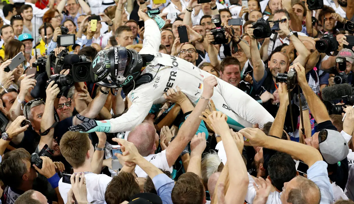 Pembalap Formula 1 tim Mercedes, Nico Rosberg melakukan selebrasi bersama timnya saat merayakan kemenangan sebagai juara Formula 1 2016 di sirkuit Yas Marina di Abu Dhabi, Uni Emirat Arab, (27/11). (REUTERS/Ahmed Jadallah)