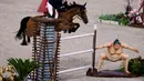 Harry Charles dari Inggris mengendarai Romeo 88 melompati patung sumo kecil saat bertanding di final individu lompat berkuda selama Olimpiade Tokyo 2020 di Equestrian Park di Tokyo (4/8/2021).
(AFP/Behrouz Mehri)