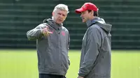 Pelatih Arsenal, Arsene Wenger (kiri) berbincang dengan staf pelatih saat sesi latihan di London Colney Arsenal, Inggris (25/4). Arsenal akan menghadapi wakil Spanyol, Atletico Madrid pada leg pertama babak semifinal Liga Europa. (AFP Photo/Ben Stansall)