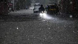 Pengendara melewati jalan yang tergenang air di tengah hujan lebat di Kolkata (20/9/2021). Hujan dilaporkan dipicu oleh sirkulasi siklon yang terbentuk di atas Teluk Benggala. (AFP/Dibyangshu Sarkar)