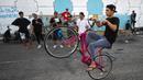 Seorang pemuda memamerkan keterampilannya mengendarai sepeda di Distrik Jadriya, Baghdad, Irak, 6 Agustus 2021. Banyak pemuda Irak di Baghdad berusaha untuk menjadi modern, bahkan ketika mereka mengakui negaranya mungkin tidak memiliki masa depan. (AHMAD AL-RUBAYE/AFP)