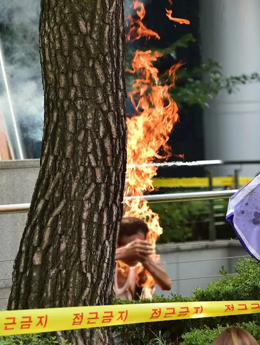 Seorang Pria membakar dirinya sendiri saat menggelar aksi unjuk rasa di depan Kantor Kedubes Jepang di Seoul, Korea Selatan, Rabu (12/8/2015). Menurut kantor berita lokal, pria tersebut berusia sekitar 80 tahun. (AFP PHOTO/JUNG YEON-JE)