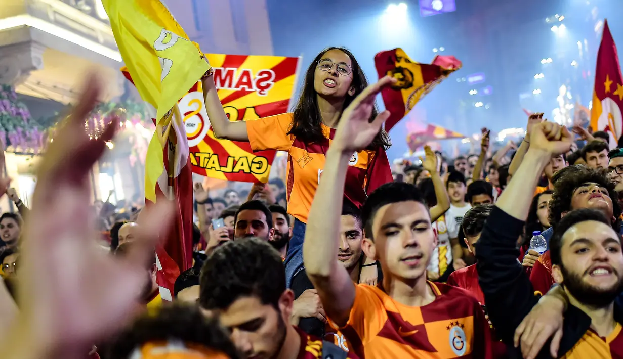 Suporter Galatasaray merayakan kemenangan timnya meraih gelar Liga Turki usai pertandingan melawan Istanbul Basaksehir di Turk Telekom Arena di Istanbul (19/5/2019). Galatasaray memastikan gelar liga Turki ke-22 usai mengalahkan Istanbul Basaksehir 2-1. (AFP Photo/Yasin Akgul)