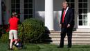 Presiden AS, Donald Trump menyapa anak laki-laki, Frank Giaccio yang tengah mendorong mesin pemotong rumput di Rose Garden, Gedung Putih, Jumat (15/9). Bocah 11 tahun itu berada di Rose Garden setelah menulis surat kepada Trump. (AP/Jacquelyn Martin)