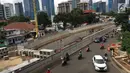 Kendaraan melintas di samping pembangunan proyek underpass Mampang-Kuningan, Jakarta, Senin (29/1). Underpass dengan panjang 860 meter ini kemungkinan besar baru bisa rampung pada April 2018 mendatang. (Liputan6.com/Immanuel Antonius)