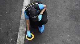 Seorang polisi melakukan penyelidikan di tempat ledakan di Bangkok (2/8/2019). Polisi setempat menduga ledakan bersumber dari benda yang diduga seperti bom rakitan di Distrik Suan Luang. Polisi kini masih menyelidiki penyebab ledakan low explosive itu. (AFP Photo/Lillian Suwanrumpha)