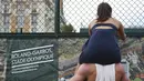 Aksi seorang wanita yang duduk di atas bahu kekasihnya saat menonton pertandingan tenis di ajang Roland Garros 2017, Prancis Terbuka, Paris,  (28/5/2017).  (AFP/Gabriel Bouys)
