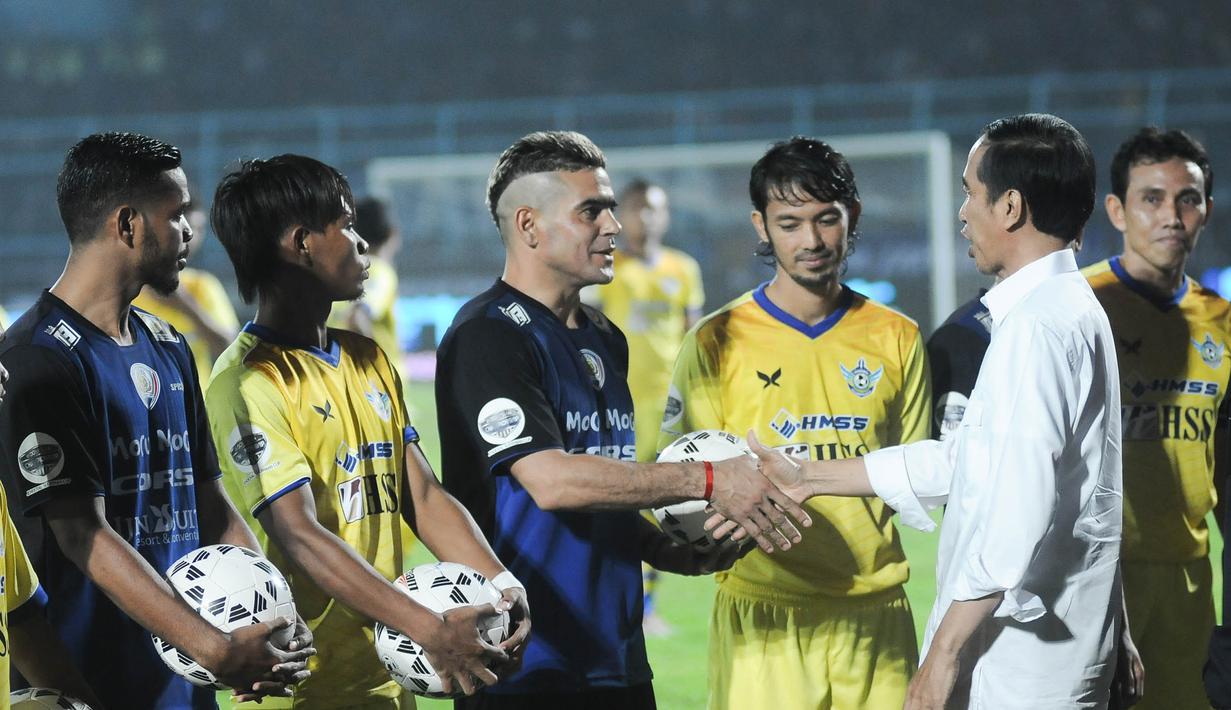 Presiden Joko Widodo bersalaman dengan penyerang Arema Cronus, Cristian Gonzales jelang laga pembukaan Piala Jenderal Sudirman melawan Persegres G.U di Stadion Kanjuruhan, Malang, Selasa (10/11/2015). (Bola.com/Kevin Setiawan)