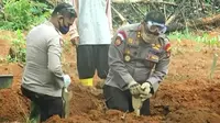 Kasat Sabhara Polrestabes Palembang AKBP Sonny Triyanto tak segan turut membantu petugas pemakaman, menggali liang lahat jenasah pasien Covid-19 di TPU Gandus Hills Palembang (Liputan6.com / Nefri Inge)