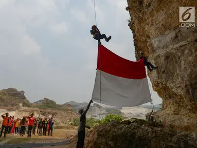 Pegiat alam bebas dan Kelompok Pecinta Lingkungan Gembala mengibarkan bendera merah putih pada HUT ke-74 RI di lokasi bekas tambang Tebing Arpam, Guha Tugu Gula, Klapanunggal, Kabupaten Bogor, Sabtu (17/8/2019). Upacara tersebut sebagai bentuk pelestarian kawasan karts. (merdeka.com/Imam Bukhori)