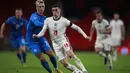 Gelandang Inggris, Phil Foden menggiring bola dari kawalan pemain Islandia, Albert Gudmundsson pada pertandingan UEFA Nations League di stadion Wembley, London (18/11/2020). Meski menang, Inggris tetap gagal lolos ke putaran final atau babak semifinal UEFA Nations League. (AP Photo/Ian Walton, Pool)