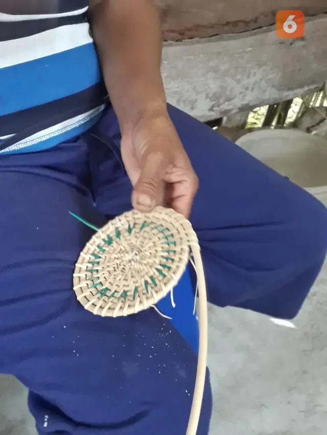 seorang pengrajin anyaman rotan di desa Desa Tomehipi, Poso
