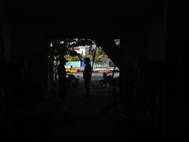Penjaga toko berbicara kepada pelanggan yang berdiri di ambang pintu saat pemadaman listrik di Wattala, Kolombo, 23 Februari 2022. Sri Lanka menerapkan pemadaman listrik bergilir akibat krisis keuangan yang memicu kekurangan bahan bakar dan melumpuhkan jaringan listriknya. (AP/Eranga Jayawardena)