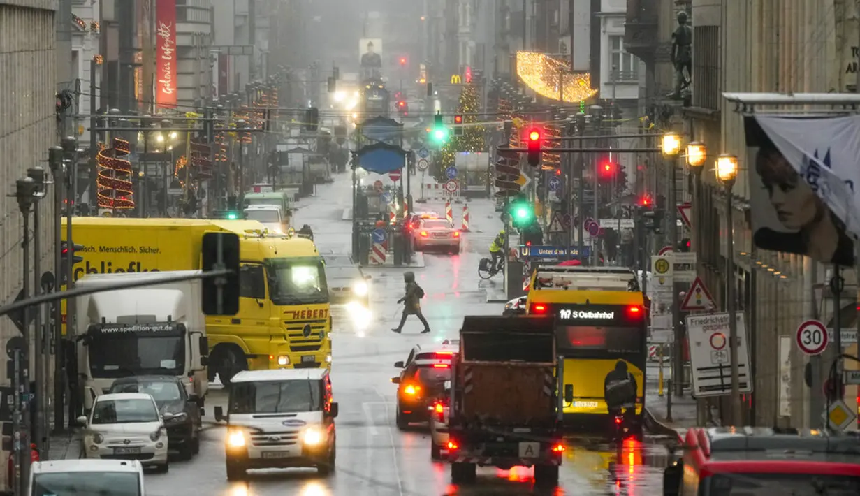 Warga melintasi pusat perbelanjaan Friedrichstrasse di Berlin, Jerman, Selasa (30/11/2021). Otoritas Jerman mewajibkan penggunaan masker di transportasi umum dan penumpang perlu divaksinasi, pulih atau negatif COVID-19. (AP Photo/Markus Schreiber)