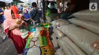 Warga membeli beras dan minyak goreng saat Operasi Pasar di Pasar Palmerah, Jakarta, Jumat (20/3/2020). Perum Bulog menjual gula pasir, beras dan minyak goreng dengan harga murah dan terjangkau yang tersebar di 35 titik pasar. (Liputan6.com/Fery Pradolo)