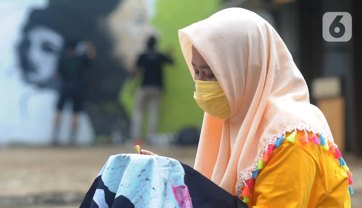 Warga menyelesaikan pembuatan batik tulis saat pelaksanaan kegiatan mural Raincity Strike #8 di Kampung Batik Cibuluh, Bogor, Minggu (22/11/2020). Kegiatan seni mural ini melibatkan puluhan seniman mural se-Jabodetabek di kampung batik. (merdeka.com/Arie Basuki)