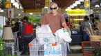 Seorang pria membeli perbekalan dan makanan yang tidak mudah rusak di supermarket sebagai persiapan menghadapi datangnya Badai Tropis Ernesto, di San Juan, Puerto Riko, Selasa (13/8/2024). (Jaydee Lee SERRANO / AFP)