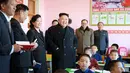 Ekspresi Kim Jong Un saat melihat anak-anak yatim belajar di ruangan kelas Sekolah Dasar Anak Yatim di Pyongyang, Korea Utara (2/2). (AFP Photo / KCNA VIA KNS / STR)