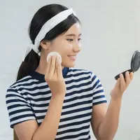 Potret wanita sedang touch up makeup (Foto: Freepik/tirachardz).