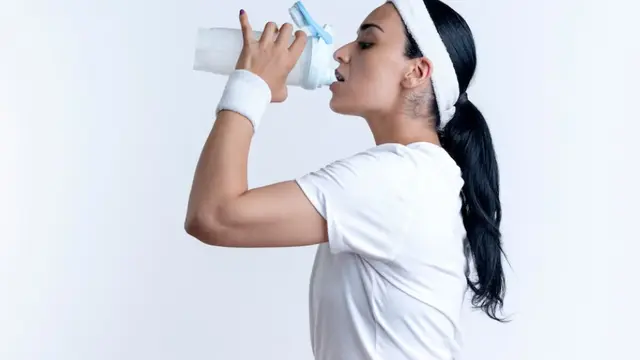 Seorang Wanita Sedang Meminum Air Putih