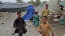 <p>Seorang perempuan yang mengenakan burqa dan anak-anaknya berjalan di depan rumah mereka di Kabul, Afghanistan, 8 Mei 2022. Taliban memerintahkan perempuan Afghanistan untuk mengenakan pakaian dari kepala hingga ujung kaki atau burqa tradisional di depan umum. (AP Photo/Ebrahim Noroozi)</p>